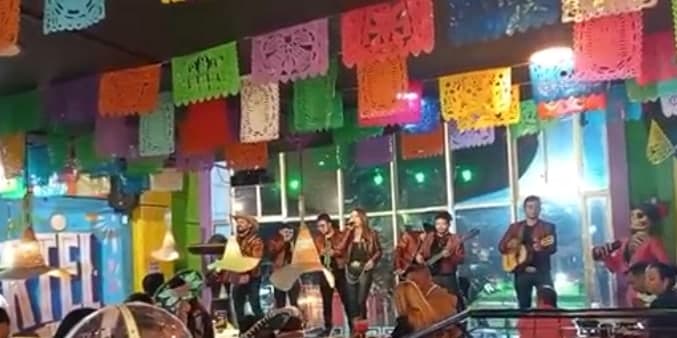 Grupo tocando en vivo bajo el papel picado del salón